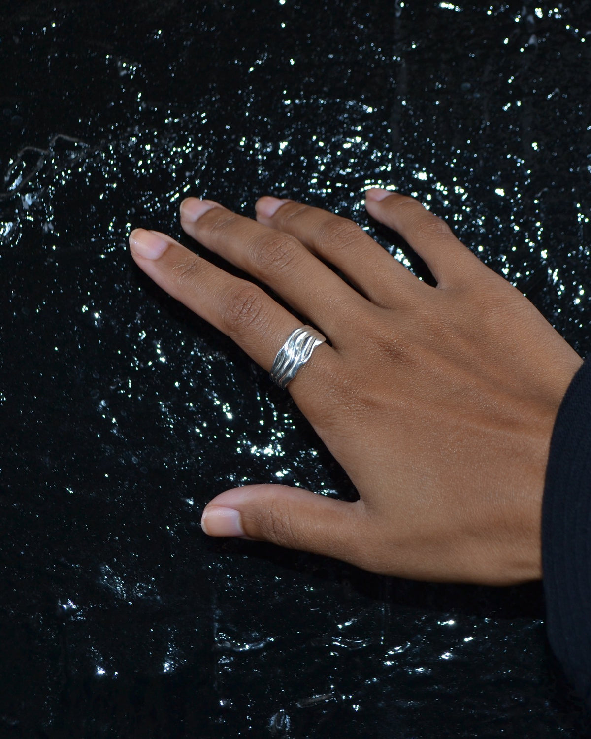 Blurr Ring in 925 sterling silver, worn on a hand against a dark London wall